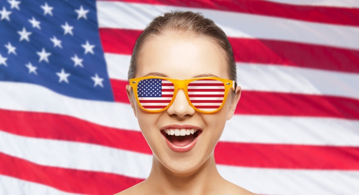 people, patriotism, national pride and independence day concept - happy teenage girl in shades with american flag