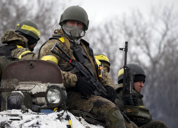Members of the Ukrainian armed forces ride on an armoured personnel carrier (APC) near Debaltseve